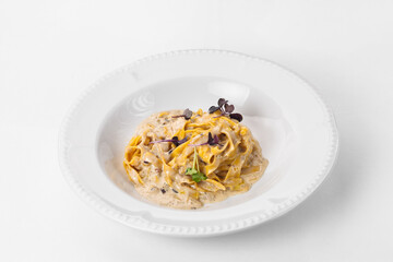 Fine cuisine on a white plate on a white background. Author's cuisine. Pasta in creamy sauce