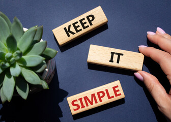 Keep it Simple symbol. Concept words Keep it Simple on wooden blocks. Businessman hand. Beautiful...