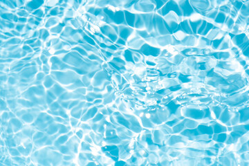 Blue water with ripples on the surface. Defocus blurred transparent blue colored clear calm water surface texture with splashes and bubbles. Water waves with shining pattern texture background.