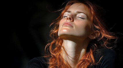 Redhead woman sunbathing, serene face, dark background, outdoor.