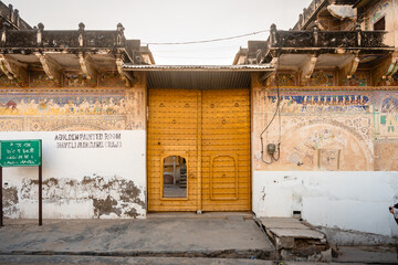 Gelbe, hölzerne, große Eingangstür oder auch Tor vor einem Haveli Haus in Mandawa in Rajasthan...