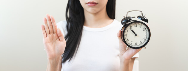 Intermittent fasting with clock, close up young woman, girl diet, waiting time to eat ketogenic low...