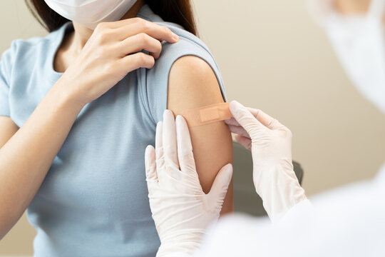 People getting a vaccination to prevent pandemic concept. Woman in medical face mask  receiving a dose of immunization coronavirus vaccine from a nurse at the medical center hospital