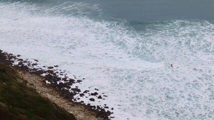 Surfer catching the waves on cloudy day