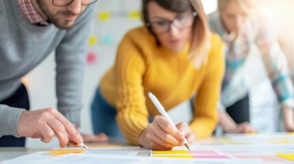 Collaborative Team Brainstorming Session Focused on Creative Planning and Strategy Development in Modern Office Environment with Colorful Sticky Notes and Notebooks