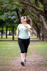 Mujer entrenando, trotando y sonriendo en un parque urbano en un hermoso día soleado. Mujer feliz...