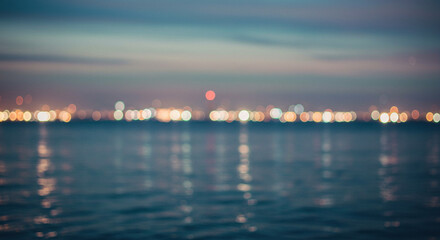Naklejka premium A cityscape at night reflected in calm waters, creating a dreamy and atmospheric scene with blurred city lights