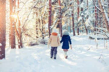 Children walk in a winter snowy forest.