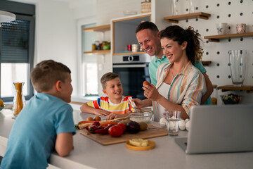 Caucasian family in casual attire prepares meal in modern kitchen, following digital recipe while...