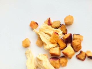 Dried pineapple and sliced plum on a bright background.