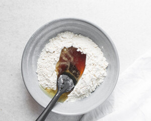 top view of mooncake dough being mixed, Overhead view of homemade mooncake dough in a grey bowl, process of making mooncakes for Lunar New Year and mid-autumn festival