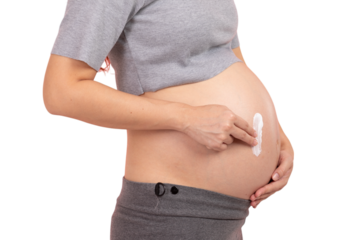 Pregnant woman applying cream to her belly for skincare and stretch mark prevention