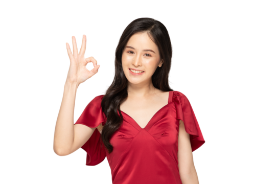 Smiling woman in red dress making OK hand gesture, expressing positivity