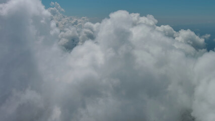 Flying through white clouds over sea