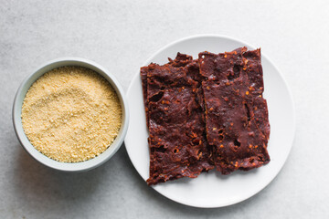 Overhead view of Nigerian kilishi on a white plate, top view of nigerian spicy beef jerky, flatlay of dried beef suya
