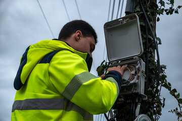 Técnico de telecomunicações a fazer intervenção numa caixa de fibra ótica, corrigindo uma...