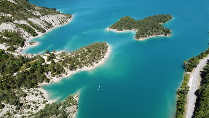 Vue aérienne panoramique du lac de Castillon dans les gorges du Verdon avec pédalo et route.
