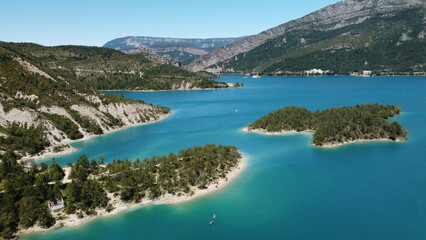 Vue a&eacute;rienne panoramique du lac de Castillon dans les gorges du Verdon avec p&eacute;dalo et route.
