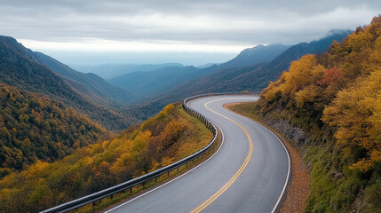 Fototapeta premium Scenic view of winding mountain road surrounded by autumn foliage