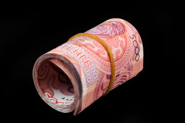 Rolled up stack of 5000 Kazakhstani tenge bills on a black background