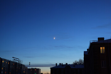 Obraz premium A serene twilight sky with a glowing moon over a stunning urban landscape captivates viewers