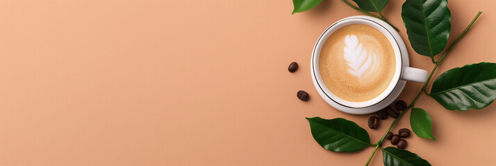 A white coffee cup with beautiful latte art rests on a light brown surface, surrounded by fresh green leaves and scattered coffee beans for an aesthetic touch.