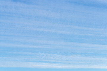 Obraz premium Long thin streaks of clouds in the blue sky