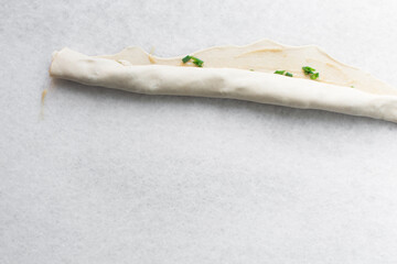 Overhead view of raw chinese scallion pancakes on a white plate, top view of homemade scallion pancakes, process of making cong you bing