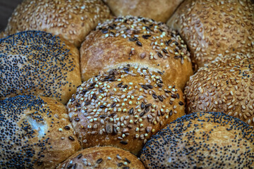 Close-up of assorted seeded bread rolls, including poppy and sesame seeds.