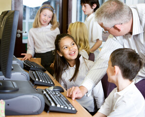 Junior School: Computer Studies. A group of primary school pupils working with their teacher in their school's computer lab.