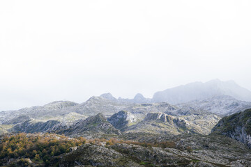 A view of the Picos de Europa National Park in Asturias, Spain. This photo was taken from the Lagos de Covadonga, by Lago de la Ercina. The sunlight is hitting the mountains as the clouds pass over.