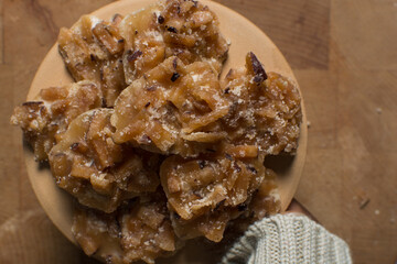 Overhead view of nigerian coconut candy on a wood countertop, top view of candied coconuts discs, flatlay of bukayo candy or coconut drops