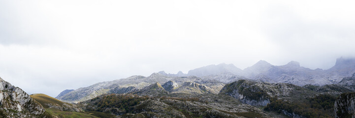 A view of the Picos de Europa National Park in Asturias, Spain. This photo was taken from the Lagos de Covadonga, by Lago de la Ercina. The sunlight is hitting the mountains as the clouds pass over.