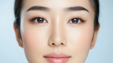 Asian Beauty: Graceful Portrait of Woman with Defined Eyebrows, Single Eyelid, and Bold Makeup Against Blue and White Background