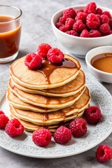 Fluffy pancake stack adorned with fresh raspberries and golden syrup. Inviting breakfast display, perfect for food enthusiasts and culinary websites. Bright, colorful, and appetizing.