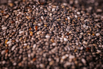 A close-up of chia seeds, showcasing their unique speckled patterns and glossy texture. These tiny seeds are a popular superfood, rich in nutrients and perfect for healthy recipes.