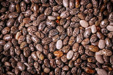 A close-up of chia seeds, showcasing their unique speckled patterns and glossy texture. These tiny seeds are a popular superfood, rich in nutrients and perfect for healthy recipes.