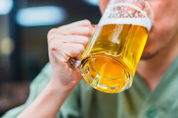 ジョッキでビールを飲む男性の手元