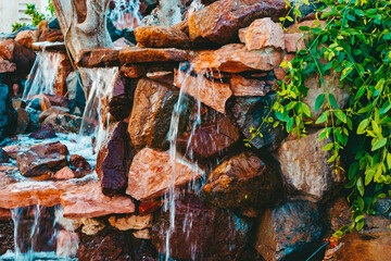 Water that flows over rocks. Decorative waterfall on the territory of an Egyptian hotel