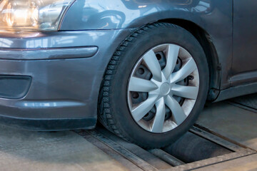 Car on brake tester machine. Annual vehicle inspection before the car registration. Automotive safety concept.