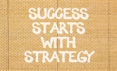 Success starts with strategy symbol. Concept words Success starts with strategy on beautiful brick...
