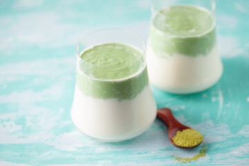 Dalgona Matcha Latte, a creamy whipped matcha in glasses, on light background.