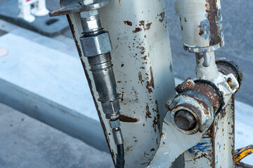 Close up of the hydraulic cylinder and adjacent parts and levers of an excavator on a construction...