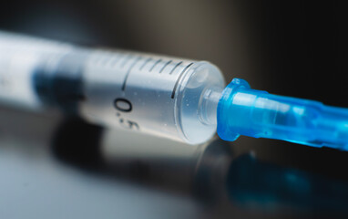 Syringe filled with liquid positioned on a dark surface