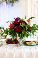 Floral display at celebration. A stunning bouquet of mixed roses enhances a festive table setting with vibrant colors and festive treats nearby.