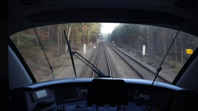 View through the windshield in the driver's cabin of a moving train