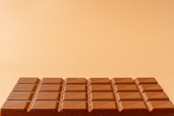 A chocolate bar with a white background. The chocolate bar is cut into squares. The squares are all different sizes