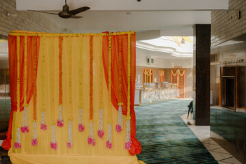 Vibrant Indian Haldi ceremony decorations featuring marigold garlands, colourful drapes, and traditional motifs, create a festive and joyful atmosphere for the pre-wedding ritual