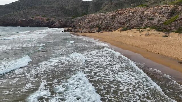 Aerial view of waves breaking on the rocks of a beach in the Calblanque Regional Park, Cartagena, Region of Murcia, Spain