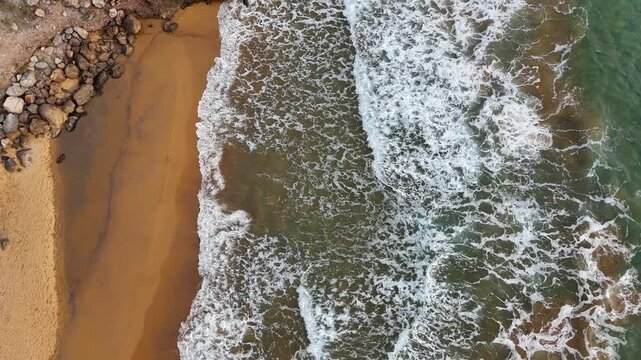 Aerial view of waves breaking on the rocks of a beach in the Calblanque Regional Park, Cartagena, Region of Murcia, Spain